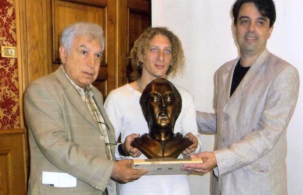 Bruno-Aloi-e-lo-scultore-Claudio-Caporaso-consegnano-il-Premio-allassessore-alla-cultura-di-Savona-1024x662  