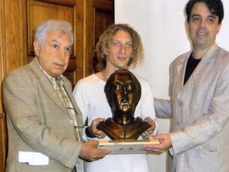 Bruno-Aloi-e-lo-scultore-Claudio-Caporaso-consegnano-il-Premio-allassessore-alla-cultura-di-Savona-326x245  